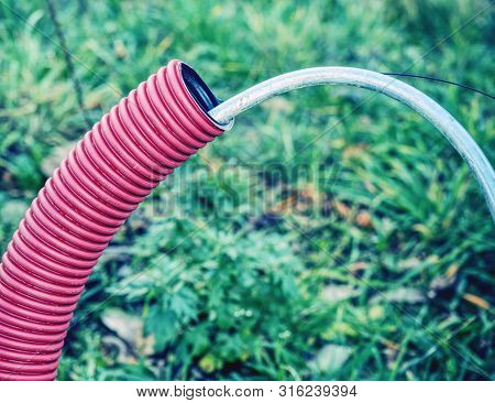 Detail Of Pvc Ribbed Tube Ready For Using Under Ground, Leaves On Wet Siol.