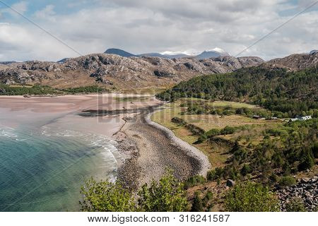 A Deserted Sandy Beach And Turquoise Sea At Gruinard Bay With Snow Capped Hills In The Distance On T