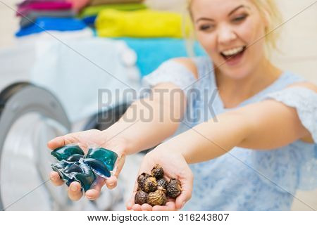 Woman Comparing Washing Laundry Nuts And Chemicals Detergent Blue Pods. Alternative Household Duties