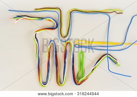 The Wires In The Insulation Are Colored Curved In Different Shapes On A Gray Background