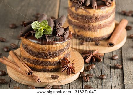 Dark Chocolate Cakes On Black Slattern Board With Mint, Cinnamon, Coffee Beans On A Wooden  Backgrou