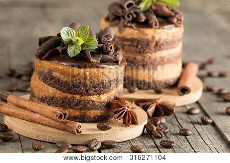 Dark Chocolate Cakes On Black Slattern Board With Mint, Cinnamon, Coffee Beans On A Wooden  Backgrou