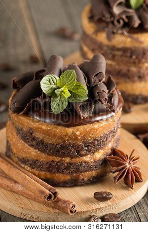 Dark Chocolate Cakes On Black Slattern Board With Mint, Cinnamon, Coffee Beans On A Wooden  Backgrou