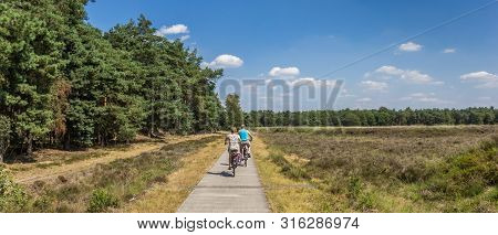 Dwingelderveld, Netherlands - July 30, 2019: Panorama Of A Couple Riding Their Bicycle In Gwingelder