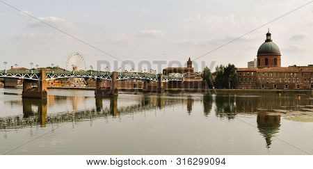 Pretty Old Bridge With Reflection Of Church Dome At The River In Toulouse.