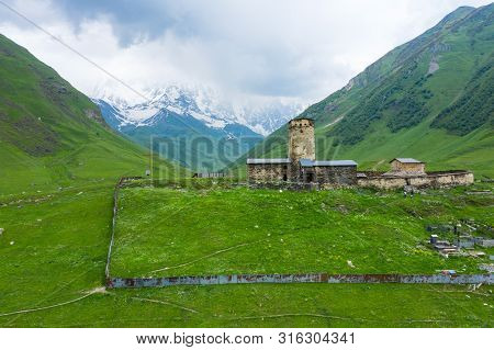 View Of The Ushguli Village At The Foot Of Mt. Shkhara. Lamaria Monastery, Rock Tower Towers And Old