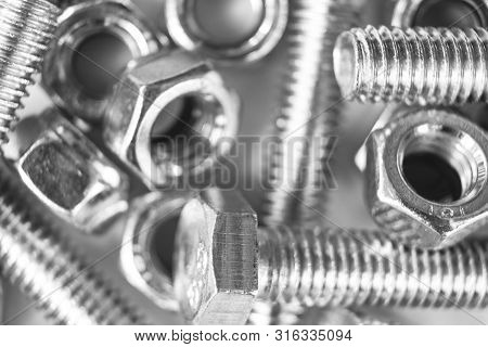 Metal Bolts And Nuts  In A Row Background. Chromed Screw Bolts And Nuts Isolated. Steel Bolts And Nu