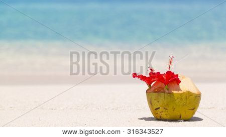 Coconut With Straw On Sand