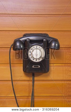 Old Phone With Dialer Disk On Wooden Background.