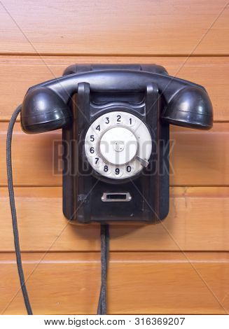 Old Phone With Dialer Disk On Wooden Background.