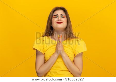 Beautiful Young Lady In A Casual Clothing Holding Hands Expressing Emotion Of Pleading For Apologize