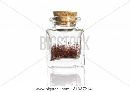 Lot Of Whole Dry Shaffron Thread In Glass Bottle With Cork Cap Isolated On White Background