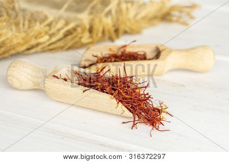 Lot Of Whole Dry Shaffron Thread In Two Scoops And Jute Cloth On White Wood
