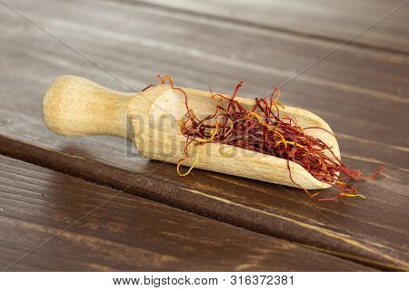 Lot Of Whole Dry Shaffron Thread With Wooden Scoop On Brown Wood