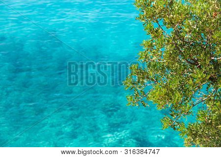 Beautiful Sandy Beach With Rock And Blue Clear Water