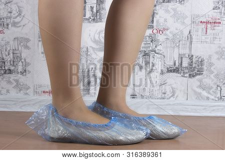 Woman Puts On Blue Shoe Covers, Close Up