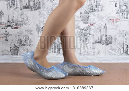 Woman Puts On Blue Shoe Covers, Close Up