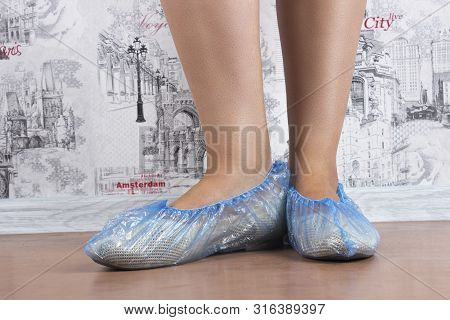 Woman Puts On Blue Shoe Covers, Close Up