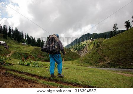 Male Tourist With Backpack Stands Near The River