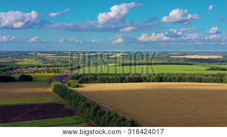 Aerial View From Quadrcopter Drone Of A Landscape With A Green Fields And Wheat Fields. The Fields A