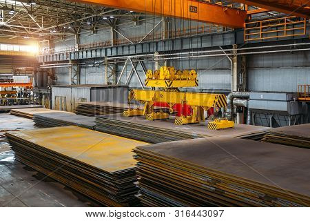 Overhead Crane With Electromagnetic Beam Grippers Lifting Steel Sheets.