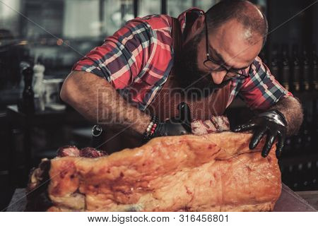 Chef cutting beef carcass in a restaurant