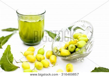 Detox Or Detoxifying Drink Of Neem Fruit In A Glass Isolated On White Along With Some Neem Fruit Or
