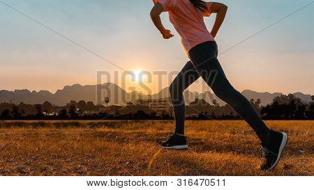 Asian Woman Enjoys Running Outside With Beautiful Summer Evening In The Countryside.