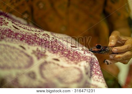 August 11 2019, Surakarta Indonesia : Close Up Hand To Make Batik On The Fabric With Canting With Bo