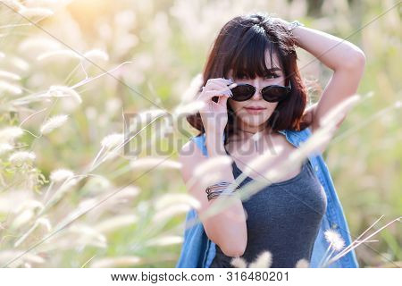 Young And Cute Girl Having A Happy Time And Enoying Amoung Grass Field In Nature