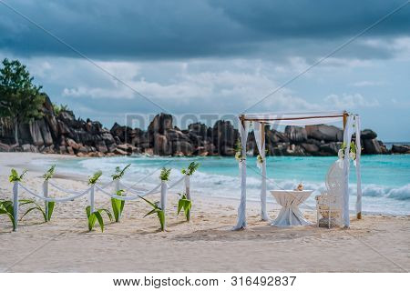 Beach Wedding Arch Ceremonial Decorated With White Flowers On A Tropical White Sand Beach. Paradise 