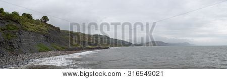 Panoramic Photo Of The Cliffs At Lyme Regis Beach In Dorset Which If Famous For Fossil Finding