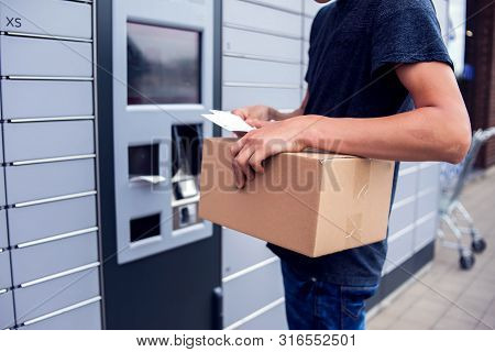 Client Using Automated Self Service Post Terminal Machine Or Locker To Deposit A Parcel For Storage