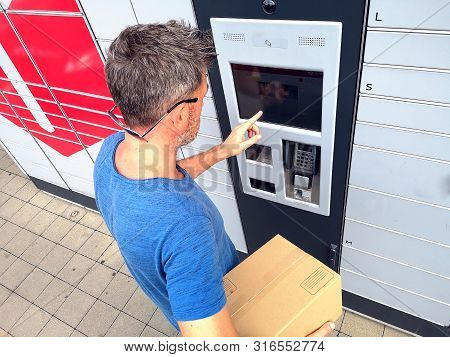 Client Using Automated Self Service Post Terminal Machine Or Locker To Deposit A Parcel For Storage
