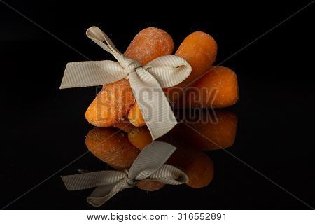Group Of Three Whole Stale  Orange Stale Baby Carrot Baby With Bow Isolated On Black Glass