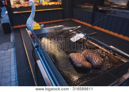 Two Juicy Duck Steaks On A Grill. Grilled Meat Fillet Cooked On A Food Festival. Fried Dish Outdoor.