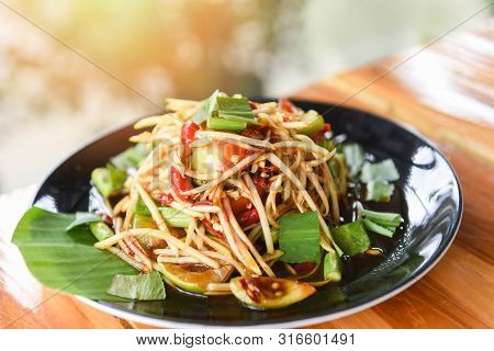 Papaya Salad Served On Dining Table / Green Papaya Salad Spicy Thai Food On Plate With Herbs And Spi
