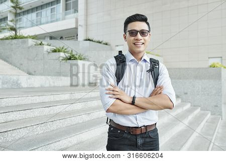 Cheerful Vietnamese Student In Sungasses Standing On Steps In Front On University With Arms Crossed