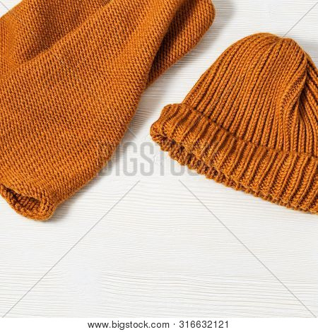 Woolen Knitted Clothing, Wool Cap And Scarf. Warm Womans Winter Clothes On White Wooden Background. 
