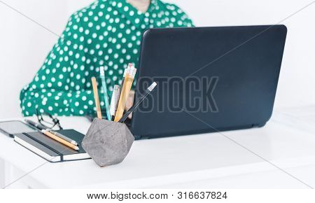 Close-up Of Hands Middle-aged Woman In Green Blouse Typing On Keyboard Laptop, Concrete Holder With 