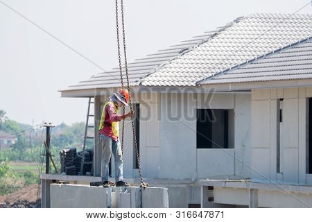 Construction Worker Are Installing Crane Hooks At The Precast Concrete Wall, Precast House Construct