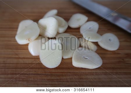 Chopped Fresh Garlic On A Wooden Chopping Board As An Ingredient For Thai Cuisine