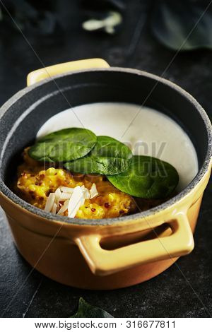Exquisite Serving Restaurant Dish of Cooked Quinoa with Carrot Celeriac Cream and Ricotta Cheese Close Up. Italian Cuisine with Kinoa, Kinwa or Kinuwa Seeds on Black Marble Table