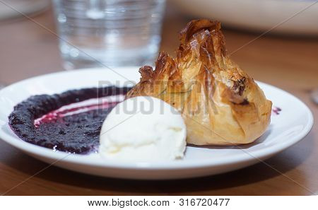 Dough Cake On A Plate With A Scoop Of Ice Cream And Sauce