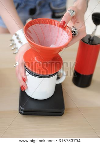 Girl Barista Brewing Drip Coffee In Red Pour Over V60 Hario Close Up Without Face. Manual Grinder
