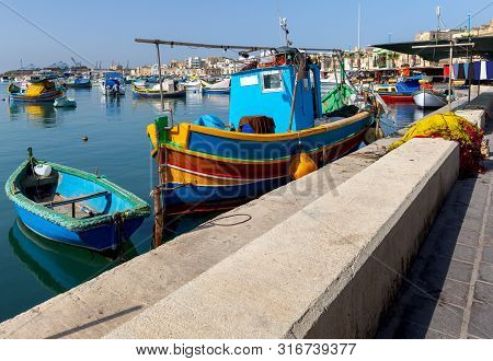 Traditional Fishing Boats Called Luzzu In The Bay Of The Village Marsaxlokk. Malta.