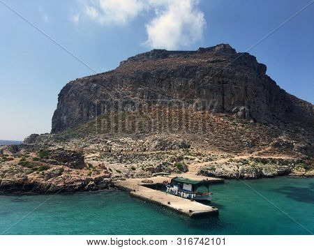 The Island Of Gramvousa In Crete, Greece. Tourist Boat Docked On The Bay Of Gramvousa Island On A Su