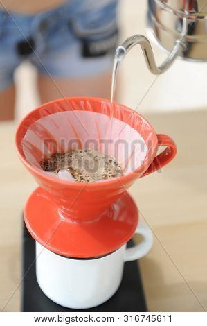 Girl Barista Brews Coffee Drip Method. Pouring Water From Gooseneck Kettle Into Red Hario V60 Funnel