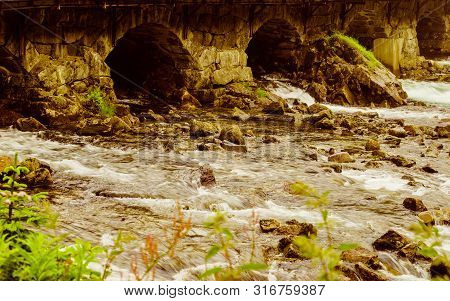 Detail View. Stone Bridge Arch And Water. Road Crossing River, Latefoss Norway.