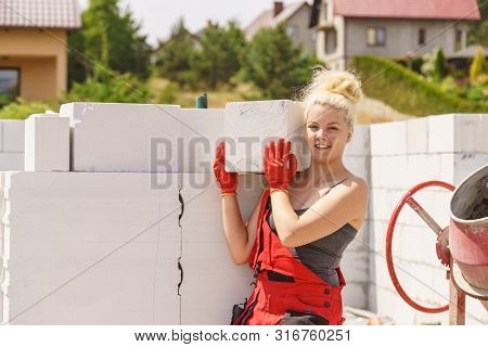 Strong Pretty Woman Working On Construction Site, Building House, Installing Gray Airbricks. Industr